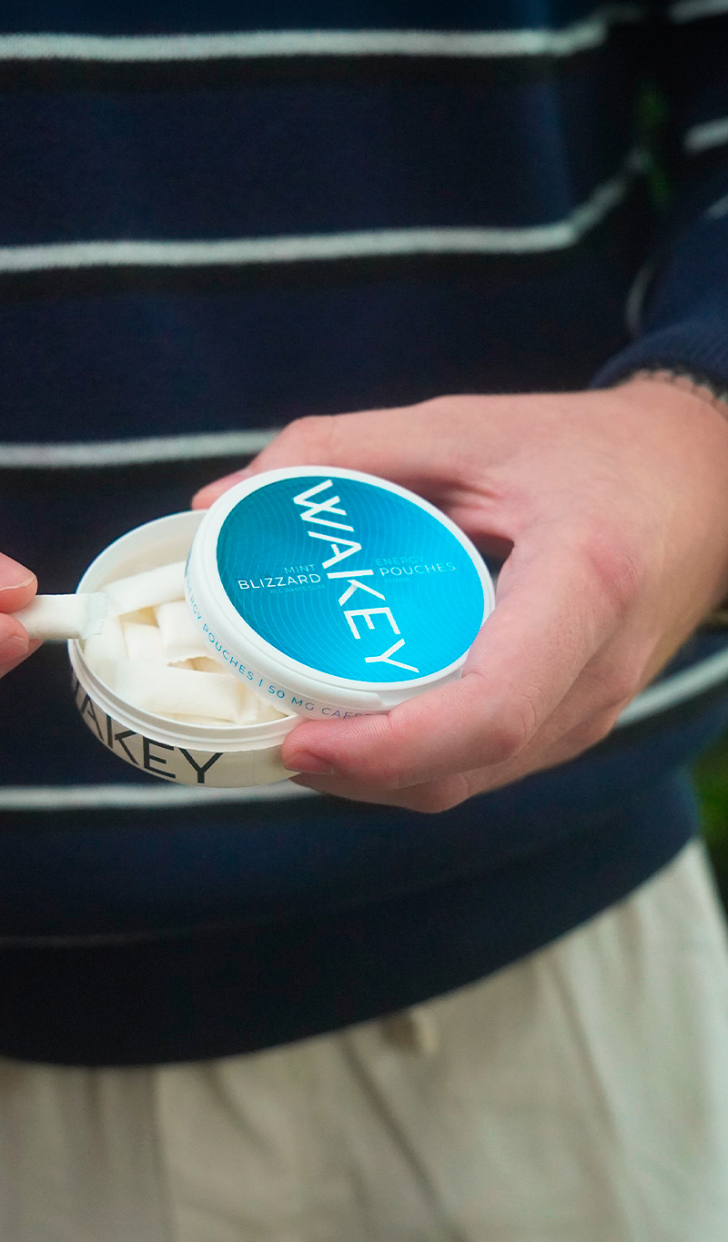 Geöffnete Dose Wakey Blizzard Mint mit sichtbaren Pouches in der Hand